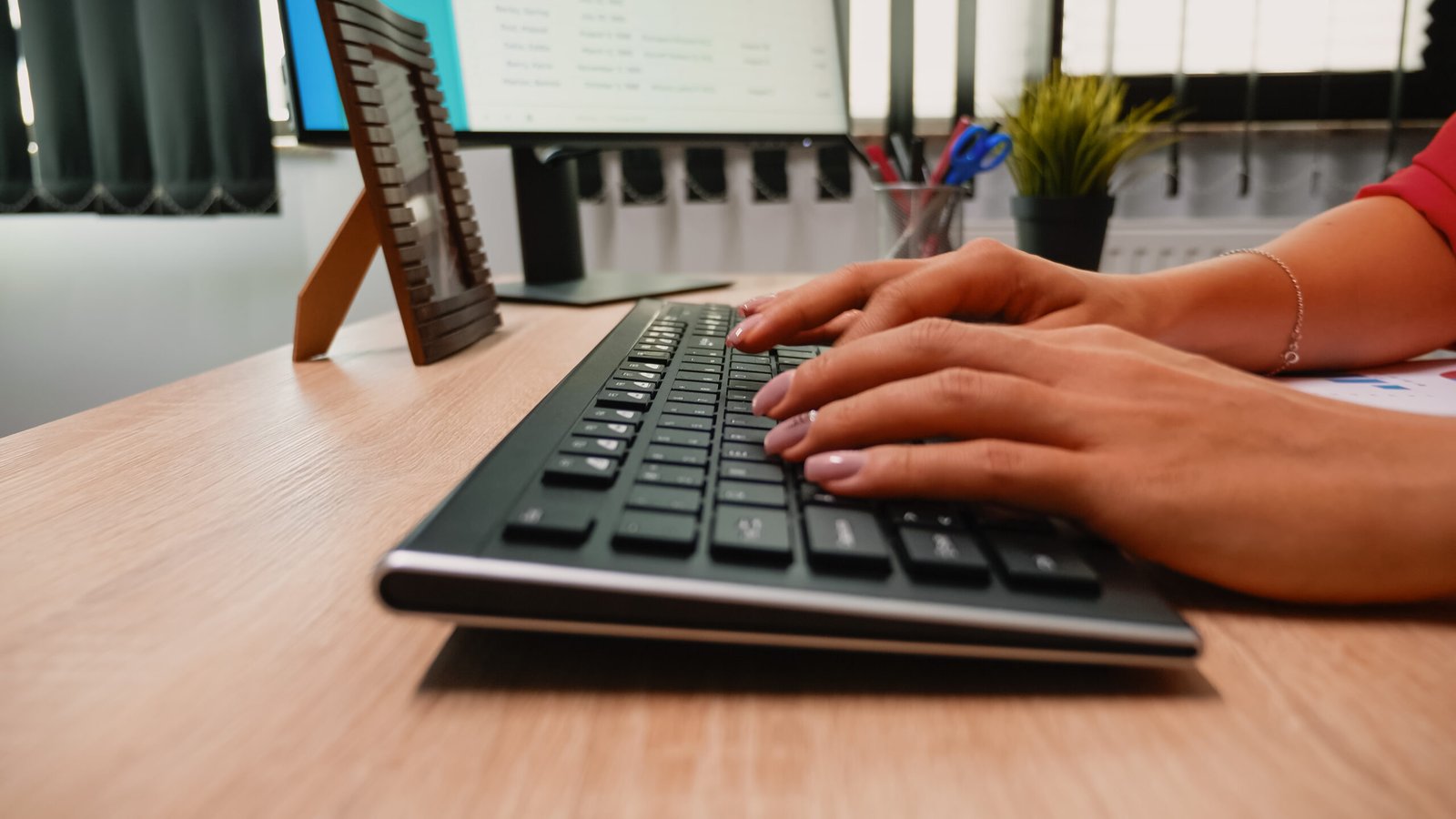 Persona escribiendo en el teclado del ordenador